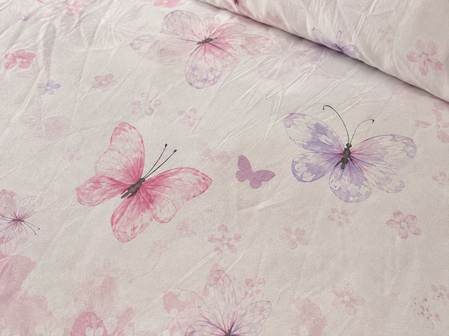 Butterfly print detail on blush bedsheet
